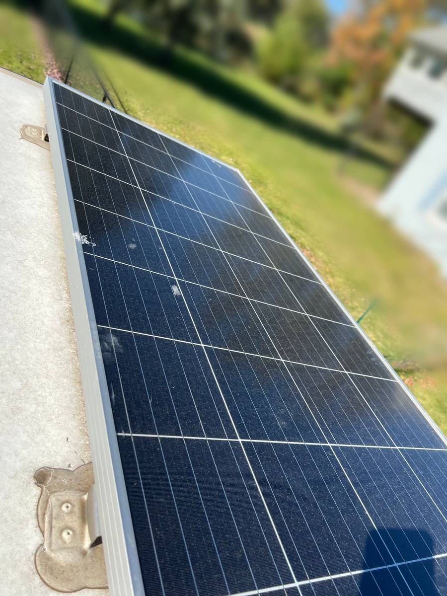 Before: a roof-mounted solar panel on an RV, its surface covered in dust and white spots, the roof membrane beside it dingy