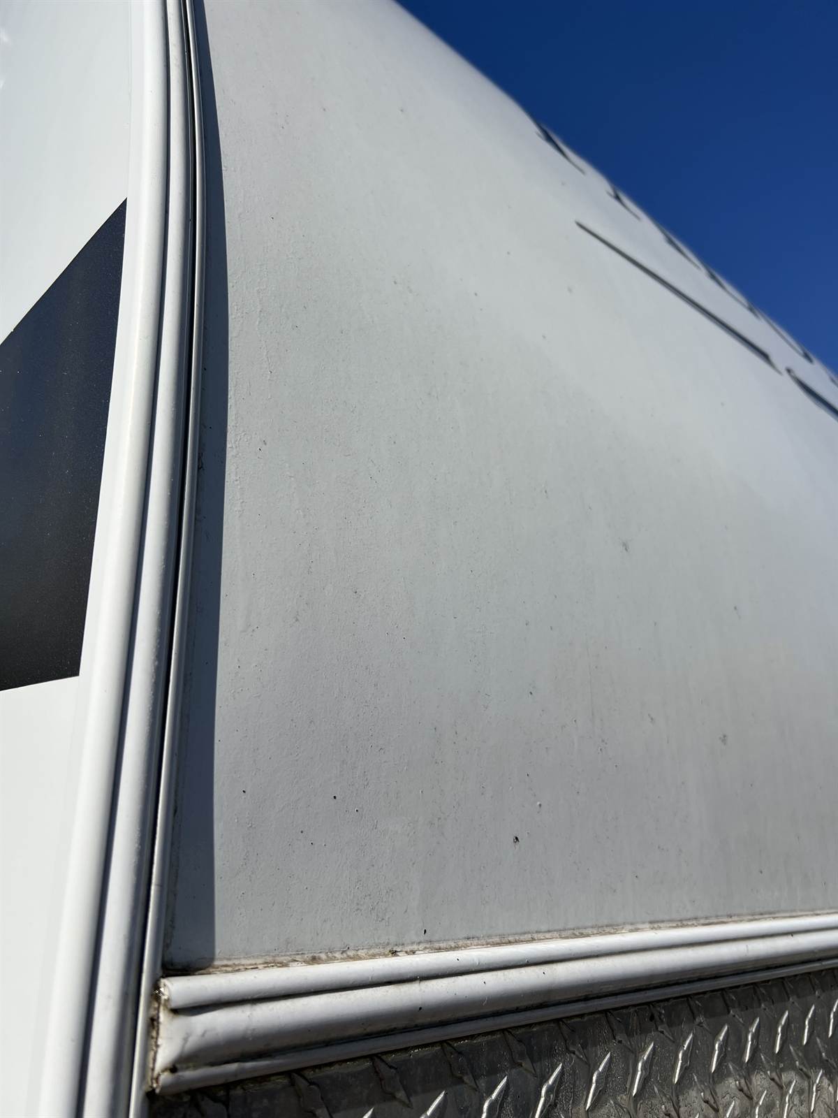 Chalky, oxidised gelcoat on the front cap of a Palomino travel trailer, before detailing